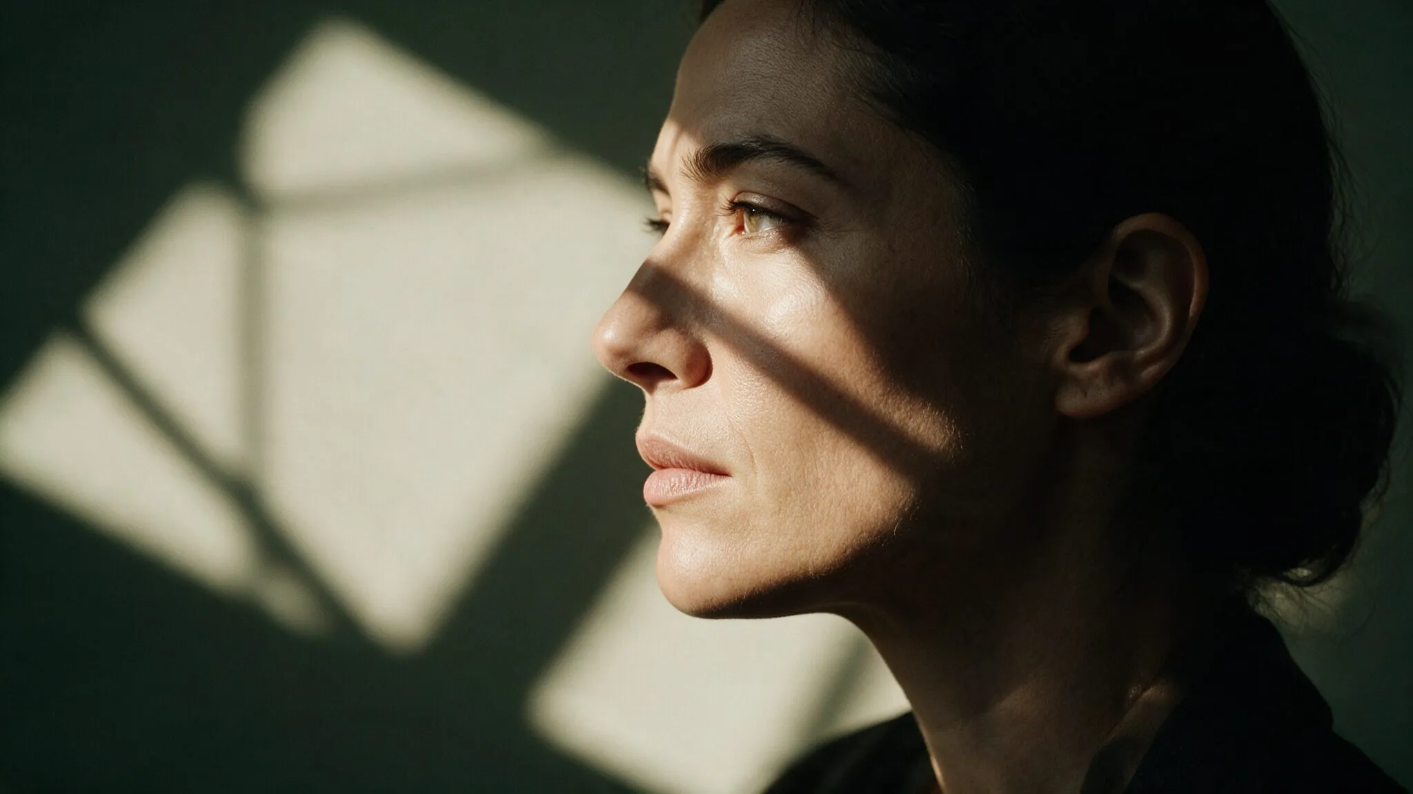 Perfil de mulher com sombras de janela projetadas no rosto